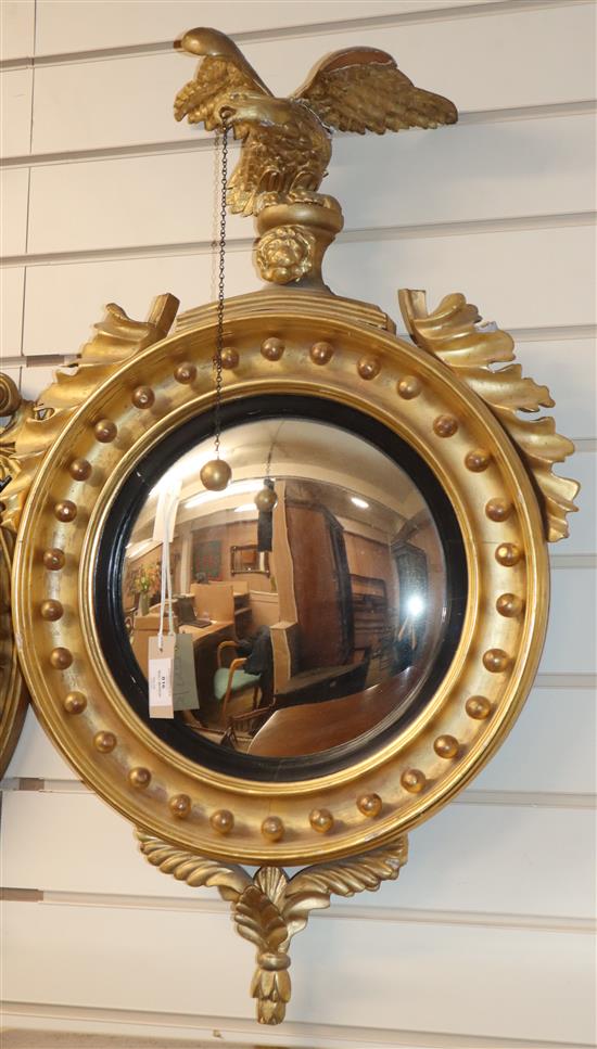 A Regency design giltwood convex wall mirror, with eagle surmount W.82cm